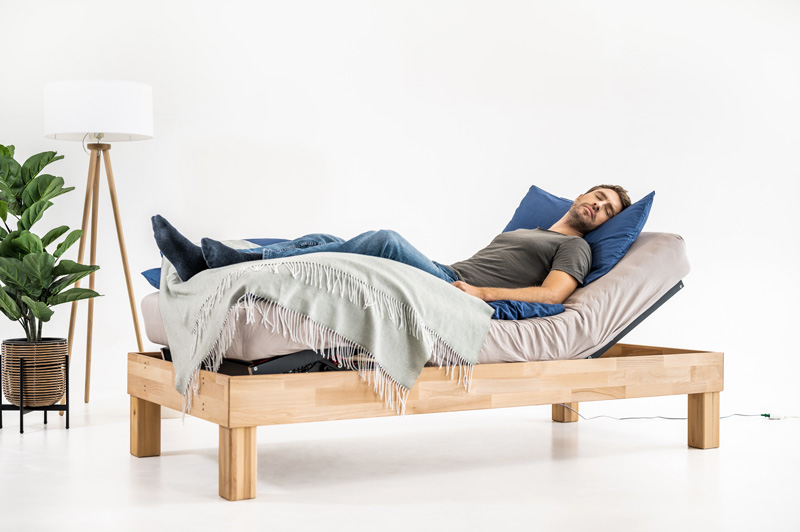Man lies relaxed in a bed with an angled Cosy2Go slatted frame